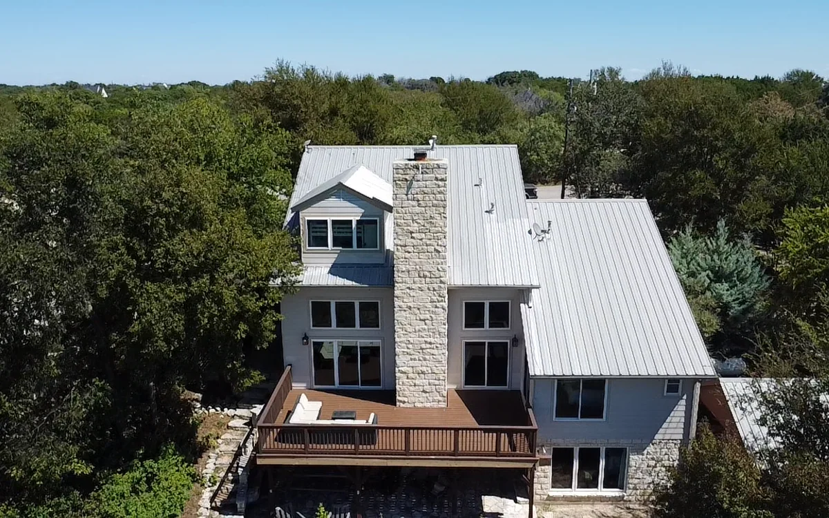 Completed light-colored metal roof on a two-story home