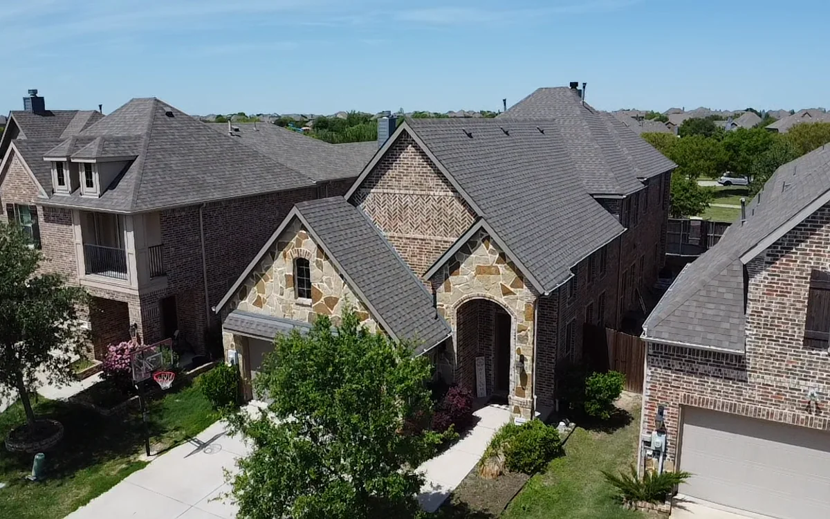 Completed architectural shingle roof on a Texas brick home